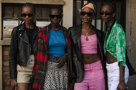 Girl in a pink crop top and flared jeans with Y2K-inspired butterfly clips